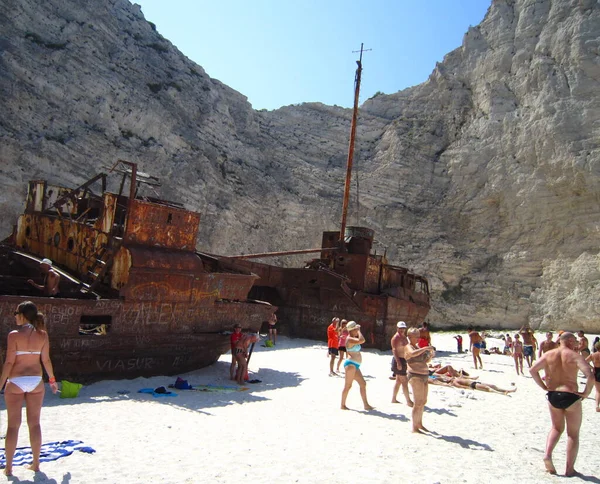 Zakynthos, Yunanistan - 23 Ağustos 2013: Zevk teknesiyle Zakynthos adasının etrafında gezinti. Beyaz kireçtaşından kayalık kıyılar. Beyaz kumlu plajlar. Navagio Körfezi enkaz plajı. Paslı bir gemi..