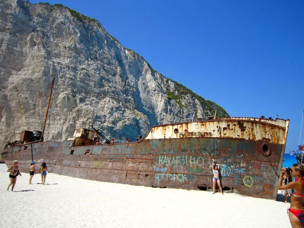 Zakynthos, Yunanistan - 23 Ağustos 2013: Zevk teknesiyle Zakynthos adasının etrafında gezinti. Beyaz kireçtaşından kayalık kıyılar. Beyaz kumlu plajlar. Navagio Körfezi enkaz plajı. Paslı bir gemi..