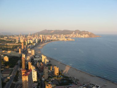 Yüksek binaların, mavi denizin ve otellerin penceresinden manzara. Costa Blanca 'da güneşli bir gün. Benidorm, İspanya