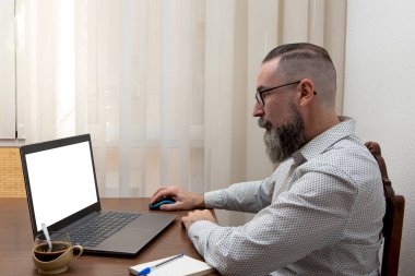 gözlüklü hipster evde bilgisayarla uzaktan çalışıyor kablosuz fare ve kablosuz ağ kullanıyor