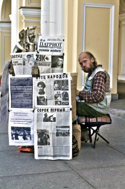 07-03-2011 St. Petersburg, Rus evsiz adam ünlü Nevsky Bulvarı 'nda, mukavva yapısı ve gazeteleriyle, SSCB' deki kimyonist çağı yüceltiyor.
