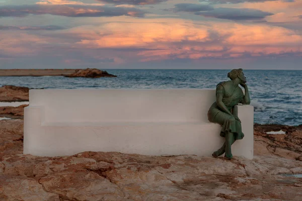 05-10-2021 Torrevieja, Alicante, İspanya Kadın deniz kenarında oturmuş ufka bakıyor balıkçı kocasının dönmesini bekliyor..