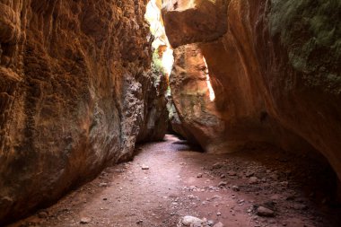 Güneş ışınlarının tepesinden büyük kayalar ve girişi olan görkemli bir mağara..