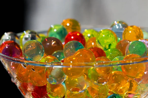 Seçici odaklı yakın plan çekimde renkli jel boncuklar, cam kap, arkaplan veya doku konseptine yerleştirilir