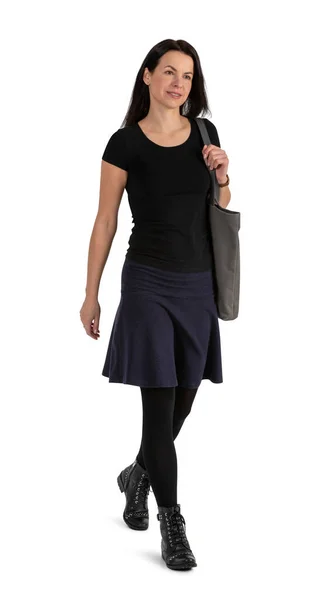 Siyah giysili, siyah çizmeli, siyah saçlı bir kadın beyaz arka planda izole bir şekilde yürüyor.