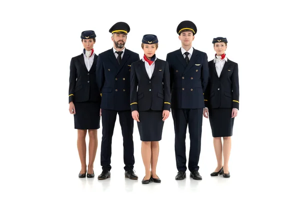 Koyu mavi üniformalı bir uçuş ekibinin portresi beyaz arka planda izole bir şekilde duruyor.
