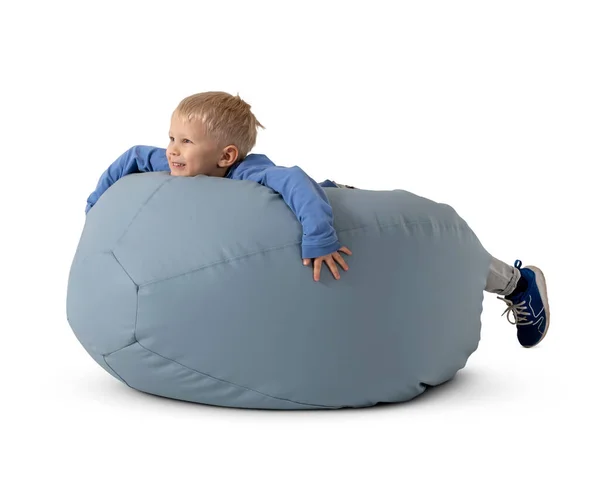 Küçük mutlu çocuk beyaz arka planda izole bir şekilde fasulye sandalyesinde yatıyor.