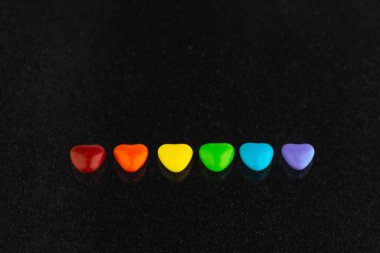 Cinsel azınlıkların mutluluğu ve eşitliği için mücadele: LGBT bayrağının gökkuşağı renginde, kısa odaklı, koyu arkaplan