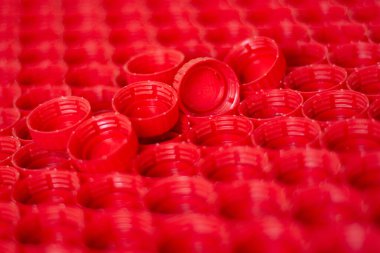Plastik konsepti geri dönüşüm. kırmızı soyut arka plan plastik kapaklar bir şişe, üst görünüm, kısa odak