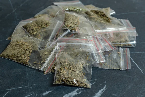 crime evidence: many packaged doses of cannabis lie on a dark surfac