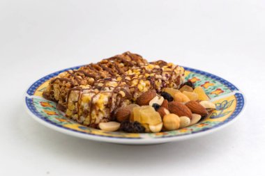 Vejetaryen tatlı: Bir sürü kuru üzüm ve bal dolu mısır gevreği tabakta, bir sürü fındık ve şekerli meyve var.