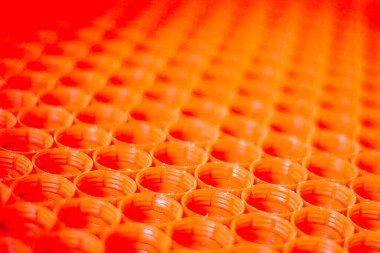 Plastik konsepti geri dönüşüm. Plastik şişe kapaklarının kırmızı soyut arkaplanı, üst görünüm, kısa odak, gelişmiş kontrast ve renk