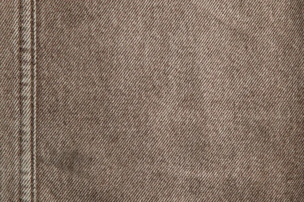 fabric grunge background, real cotton denim, brown, wrinkles, frayed, seam on the canvas, close