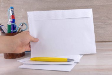 Noel hediyeleri: Çocuk, Noel Baba 'ya mektuplar için zarflar hazırladı. Tahta bir masa.