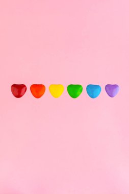 Cinsel azınlıkların mutluluğu ve eşitliği için mücadele: LGBT bayrağının gökkuşağı renginde, kısa odaklı, pembe arkaplan