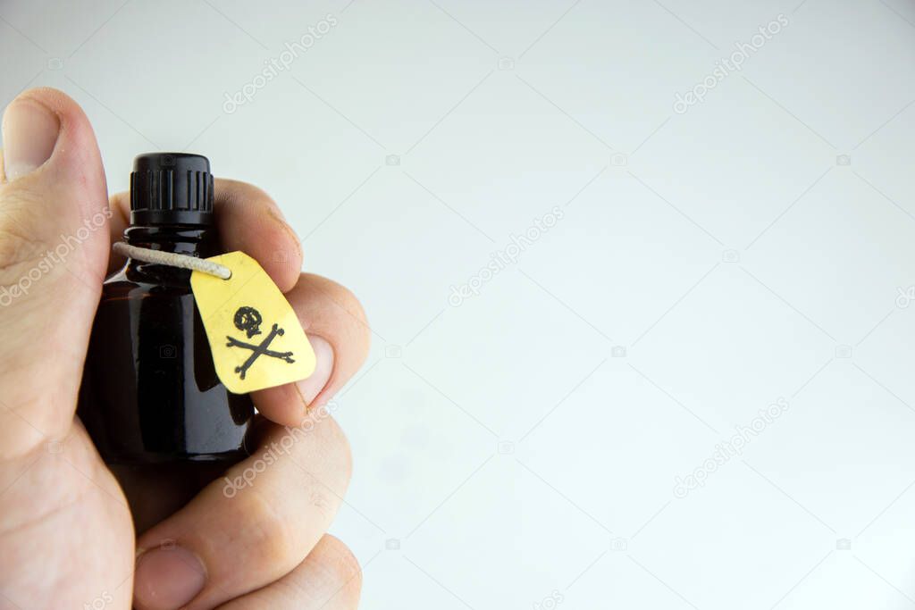 a vial of poison in a mans hand on a light background,overexposure, toning