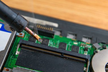 Mikroçipli bir bilgisayar panosunun üzerine tüten lehim.