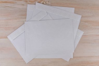 Giden mektuplar: Ofisteki ahşap bir masanın üzerinde birkaç boş beyaz zarf.