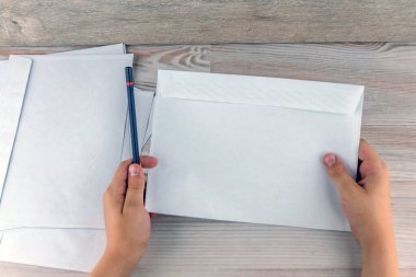 Çocuk boş bir zarf tutuyor. İçinde yazıtlar için boş yer var.