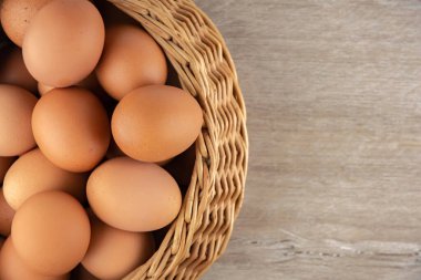 Hasır sepet, diyet kahverengi yumurtalar, üst manzara, ahşap bir masanın üzerinde.