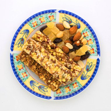 Vejetaryen tatlı: Bir sürü kuru üzüm ve bal dolu mısır gevreği tabakta, bir sürü fındık ve şekerli meyve var.