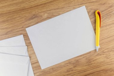 Giden mektuplar: Ofisteki ahşap bir masanın üzerinde birkaç boş beyaz zarf, geliştirilmiş kontrast