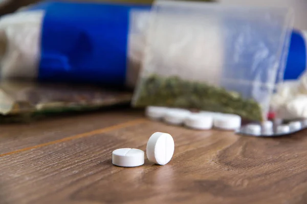 Uyuşturucu kaçakçılığı - bir grup uyuşturucunun ortasında birkaç hap: kokain, eroin, marihuana, amfetaminler masada