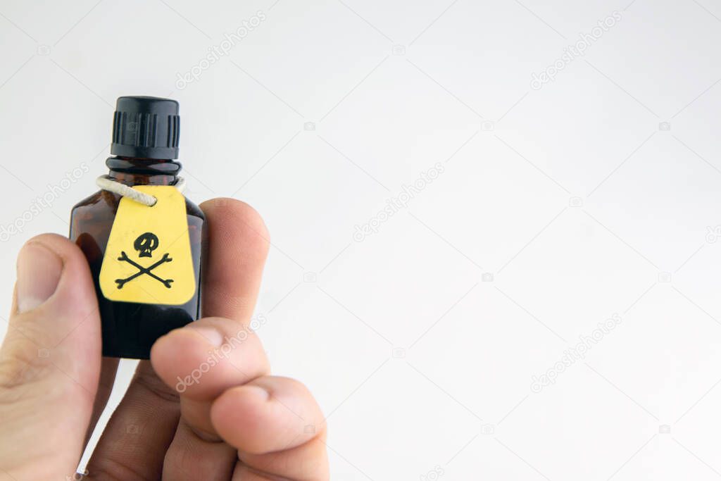 a vial of poison in a mans hand on a light background, verexposure, toning
