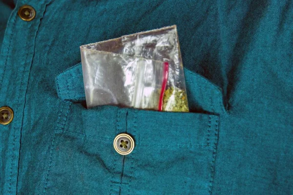 In the pocket of the shirt, a bag of synthetic smokers is sticking out - spice