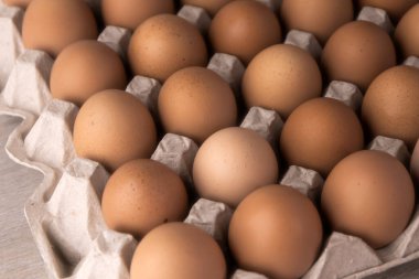 Koruyucu karton tepside bir sürü taze kırmızı yumurta.