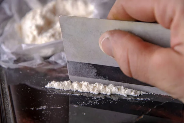 Bir uyuşturucu ve plastik kartla ambalajlanmış kokain şeridi.