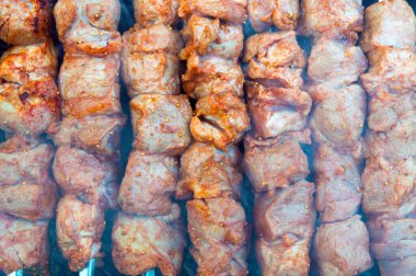 Şişte domuz kebabı kömürde kızartılır, barbeküde duman, pişirmenin başlangıcı, kapat.