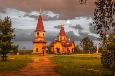Rusya 'daki kırsal Avrupa ahşap kilisesi, çan kulesi, şapel, fırtınadan önceki akşam.