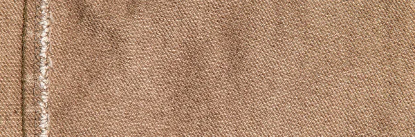 fabric grunge background, real cotton denim, brown, wrinkles, frayed, seam on the canvas, close