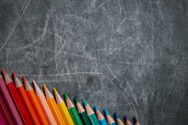 Okula dönüş: çok renkli kalemler siyah karatahtaya, kısa odaklı, kısmi bulanık