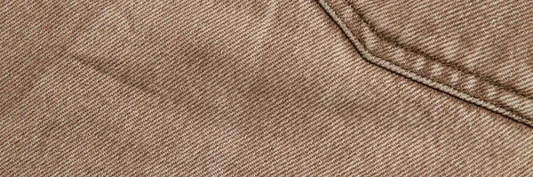 fabric grunge background, real cotton denim, brown, wrinkles, frayed, seam on the canvas, close