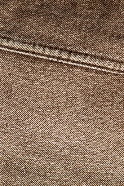 fabric grunge background, real cotton denim, brown, wrinkles, frayed, seam on the canvas, close