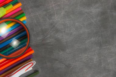 çok renkli okul malzemeleri siyah karatahtanın üzerinde, kısa odaklı, kısmi bulanık