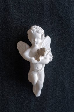 Sevgililer Günü, Noel: Beyaz bir meleğin antika heykeli elinde haçla, siyah üzerinde