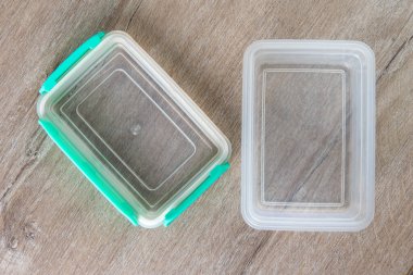 Çevre dostu şeffaf plastik gıda depolama kabı, renk kapağı, ahşap bir masa, yakın, kısa odaklı