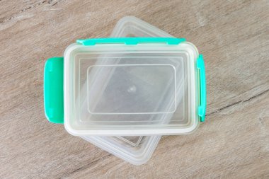 Çevre dostu şeffaf plastik gıda depolama kabı, renk kapağı, ahşap bir masa, yakın, kısa odaklı