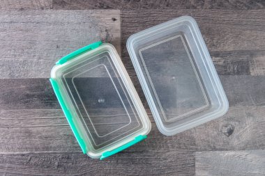 Çevre dostu şeffaf plastik gıda depolama kabı, renk kapağı, ahşap bir masa, yakın, kısa odaklı