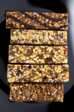 Vejetaryen diyeti: Beyaz ve kısa odaklı siyah bir tabakta kuru üzüm ve bal içeren birkaç mısır gevreği.