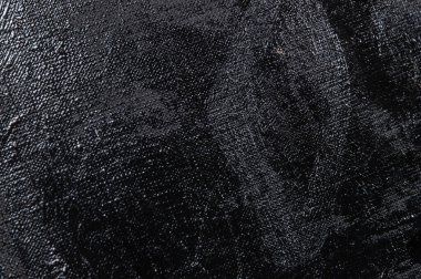 Karanlık yaratıcı arka plan, pürüzlü keten branda siyah astar ile örtülü, ışığın yansımaları. Tonlama, bulanıklaştırma, seçici odaklanma. 