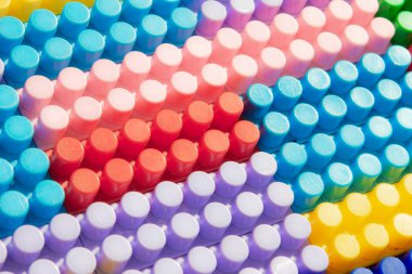 Çocuk oyun arka planı: Plastik çok renkli tuğlalar, bulanık, seçici odak düzlemi 