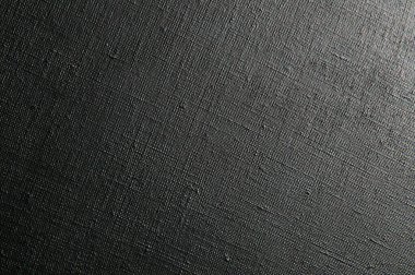 dark creative background: black primed linen canvas, uneven lighting, toning  clipart