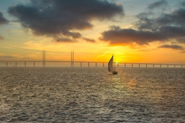 210501 Malmö - İsveç, Günbatımında yelkenli Öresund köprüsünün yanında
