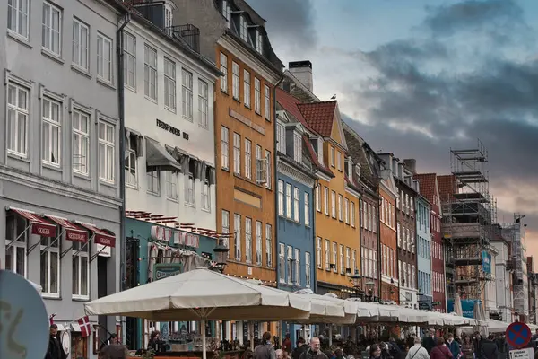 Koppenhága, Dánia - Július 1, 2020 Street view of the colorful building in Nyhavn in Cophenhagen with people walking the street in front. — Stock Fotó