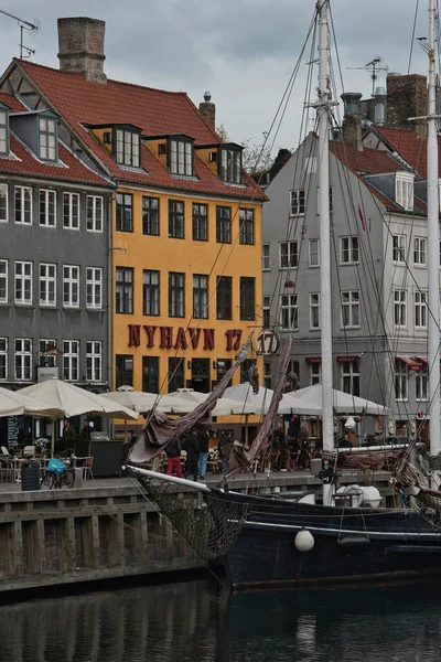 Koppenhága, Dánia - Július 1, 2020 Street view of the colorful building in Nyhavn in Cophenhagen with people walking the street in front. — Stock Fotó