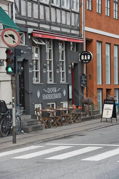 Kopenhagen, Denemarken - 1 juli 2020 Street view of the colorful building in Nyhavn in Cophenhagen with people walking the street in front. — Stockfoto